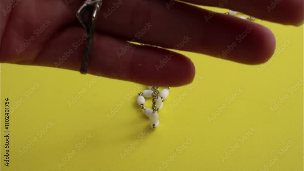 Hand holding rosary with crucifix Hand holding rosary with crucifix