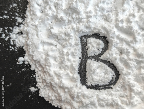 White powder on a black background. Letters B. Vitamin B. Bio hacking concept. Copy space photo