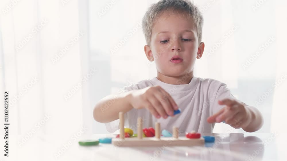 Boy is playing with toys to develop his motor skills. Learn color nursery concept. Child is playing with rings. Child is developing skills in developing motor skills with a ring of toys lifestyle. Boy is playing with toys to develop his motor skills. Learn color nursery concept. Child is playing with rings. Child is developing skills in developing motor skills with a ring of toys lifestyle.