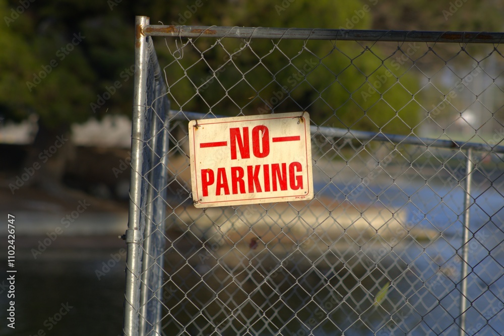 no parking sign with red letters