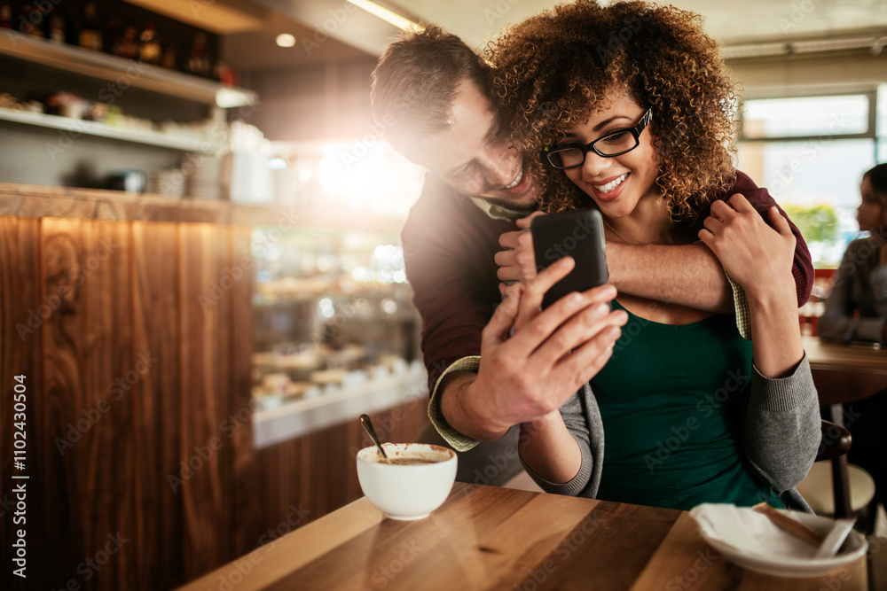 Young couple using a smart phone in a cafe Young couple using a smart phone in a cafe