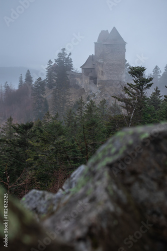 Foggy Outdoor Scene of Kasperk Castle in Southwestern Bohemia. European Landmark in Czech Republic. Vertical Shot of Medieval Architectural Building on Hill with Trees. photo