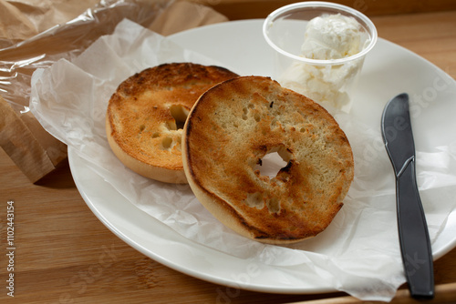 A view of a plate of bagels and cream cheese. photo