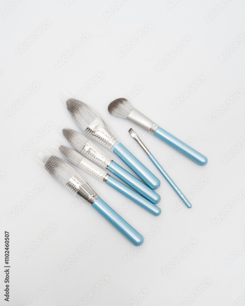 blue cosmetic brushes lie on a white background blue cosmetic brushes lie on a white background