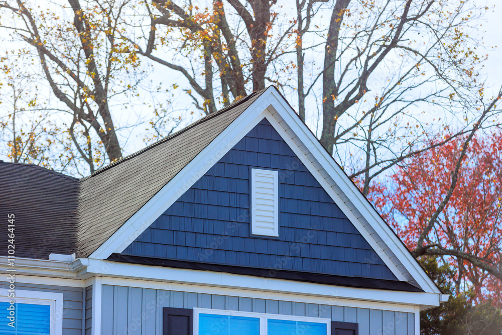 Reveals elegant design of gray house highlighting shingles on roof surrounding, unique architectural details
