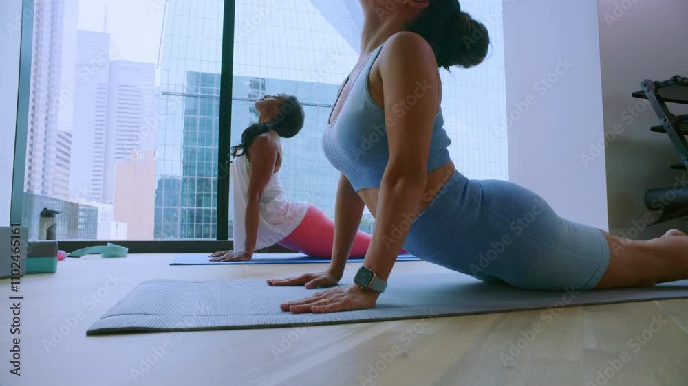 Athletic women arch into a pose while practicing yoga Athletic women arch into a pose while practicing yoga
