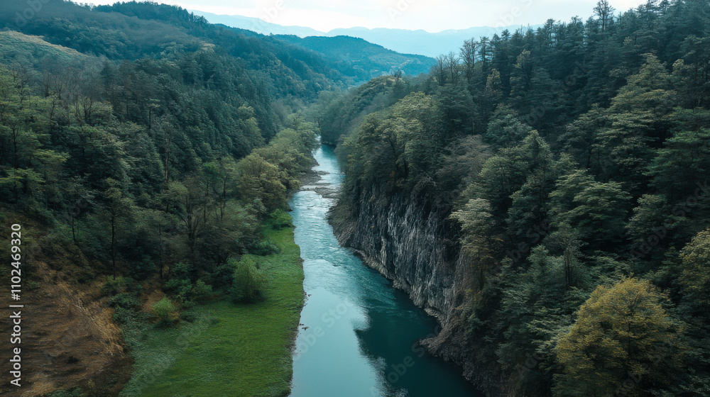 Aerial view of a serene river winding through lush green mountains on a sunny day in a remote wilderness area Aerial view of a serene river winding through lush green mountains on a sunny day in a remote wilderness area