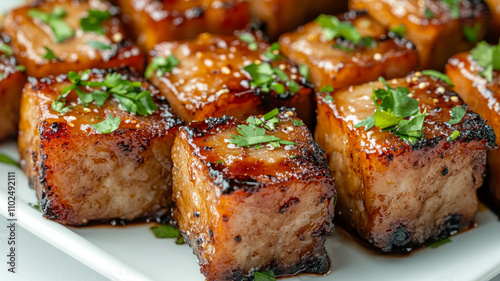 Delicious grilled glazed pork cubes garnished with herbs.