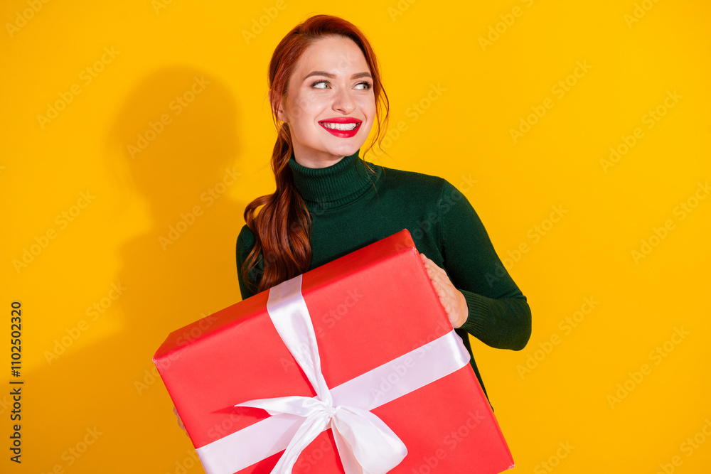 Photo of charming positive woman wear green turtleneck holding present box empty space isolated yellow color background Photo of charming positive woman wear green turtleneck holding present box empty space isolated yellow color background