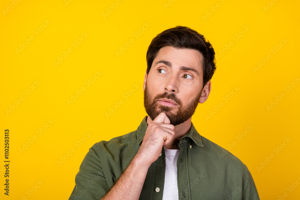 Portrait of nice young man look empty space wear khaki shirt isolated on yellow color background Portrait of nice young man look empty space wear khaki shirt isolated on yellow color background
