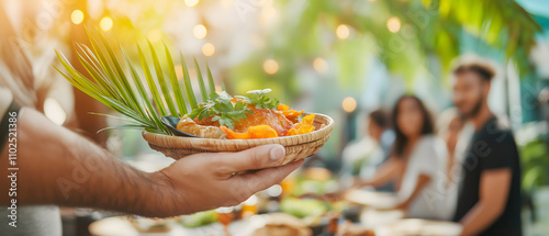 Travel concept of street foods and local cuisine. A hand holds a vibrant plate of food with greenery, set against a lively gathering in a tropical atmosphere.