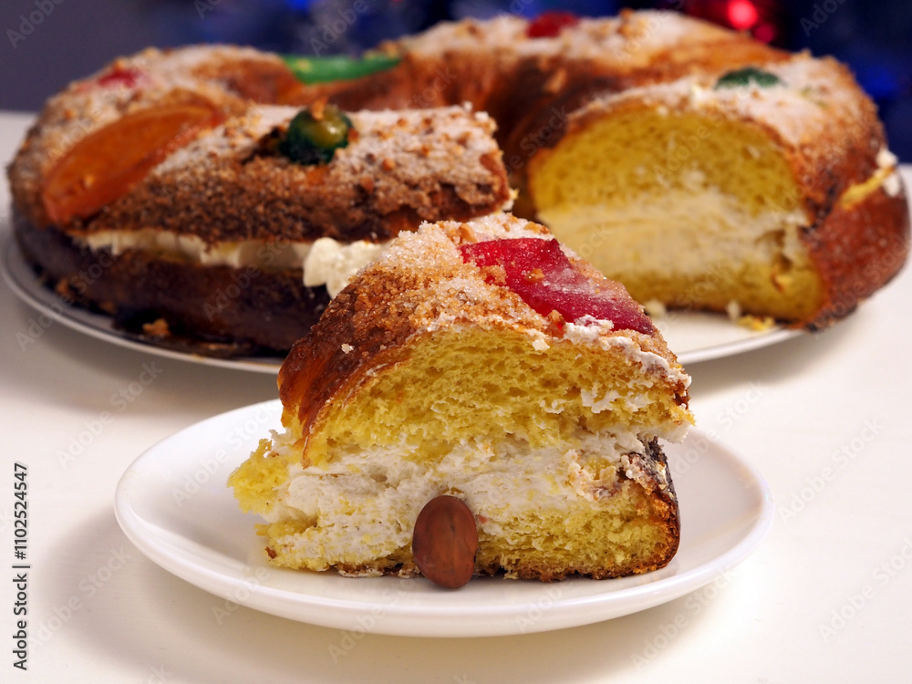 Slice of Traditional Spanish Roscon de Reyes with Cream Filling and Hidden Surprise for Epiphany Celebration Slice of Traditional Spanish Roscon de Reyes with Cream Filling and Hidden Surprise for Epiphany Celebration