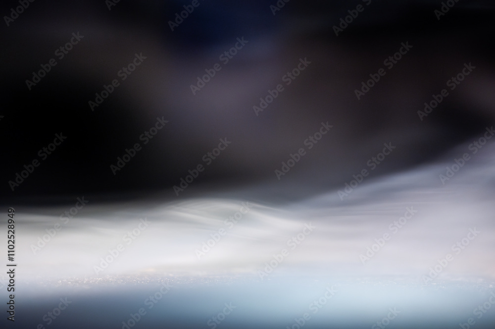 Wisps of delicate smoke swirl gracefully above a calm surface in low light Wisps of delicate smoke swirl gracefully above a calm surface in low light