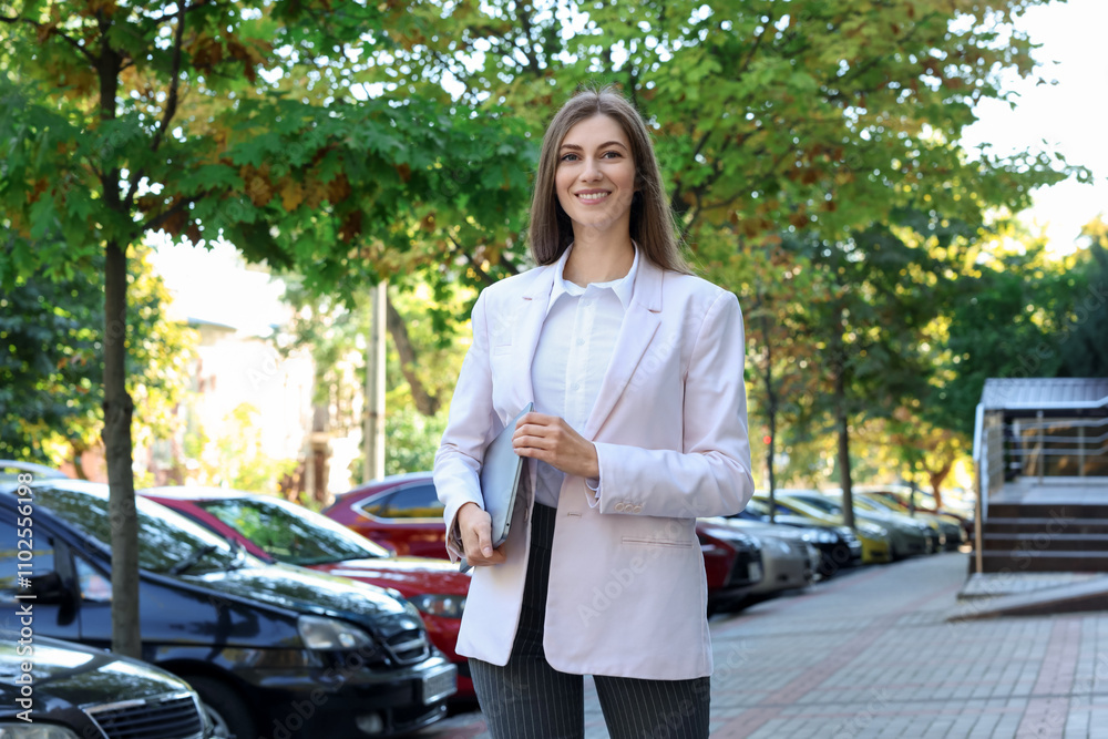 Portrait of young woman with laptop wearing stylish suit outdoors Portrait of young woman with laptop wearing stylish suit outdoors
