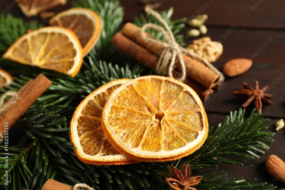 Different spices, dried orange slices and fir tree branches on wooden table, closeup. Christmas season Different spices, dried orange slices and fir tree branches on wooden table, closeup. Christmas season