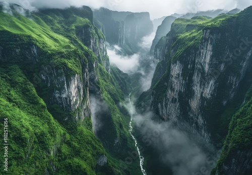 Spectacular Aerial View of Majestic Mountain Gorge Surrounded by Lush Greenery and Mist, Capturing Nature's Raw Beauty in a Dramatic Landscape Scene