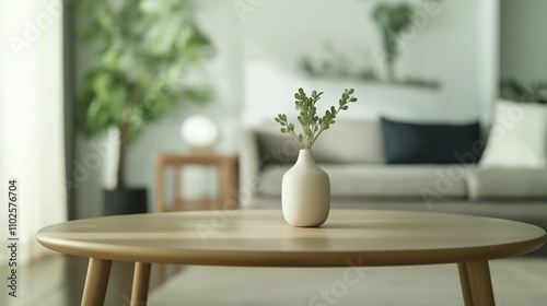 Stylish home interior featuring a simple vase with greenery on a wooden table in a modern living room.