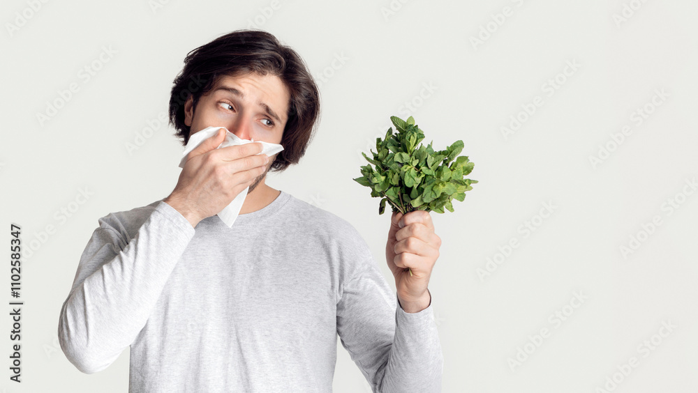 Man fighting with spring allergies and covers his nose with napkin Man fighting with spring allergies and covers his nose with napkin
