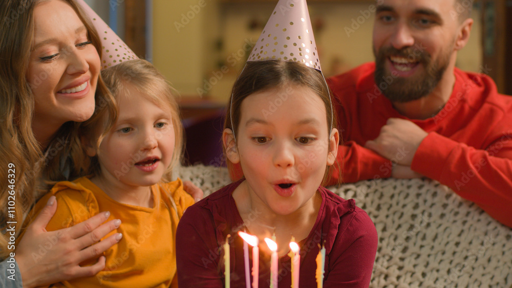 Happy child Caucasian family celebrate birthday little girl kid daughter baby birth celebration joyful parents in festive hats surprise congratulate children blowing cake candles wish home party fun Happy child Caucasian family celebrate birthday little girl kid daughter baby birth celebration joyful parents in festive hats surprise congratulate children blowing cake candles wish home party fun