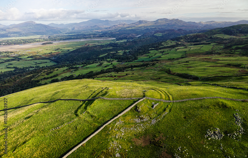 Moel Goedog prehistoric hillfort Harlech, Wales. 2 concentric Bronze Age ramparts contain possible earlier enclosure. Aerial N. to Snowdonia mountains