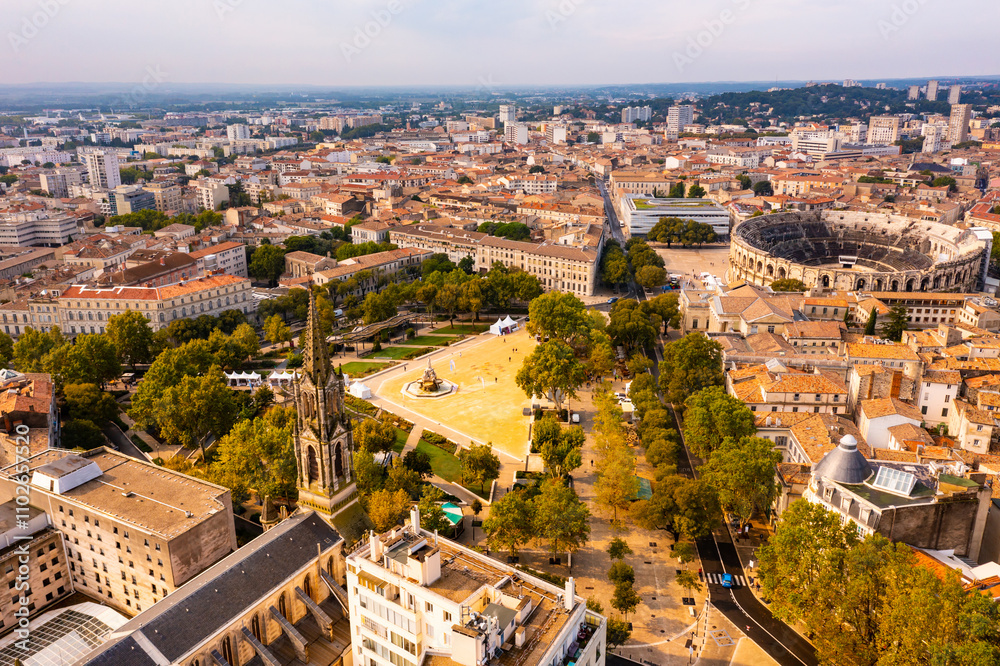 Fototapeta premium Aerial view of historical area of French city of Nimes overlooking restored antique Roman amphitheatre on sunny autumn day