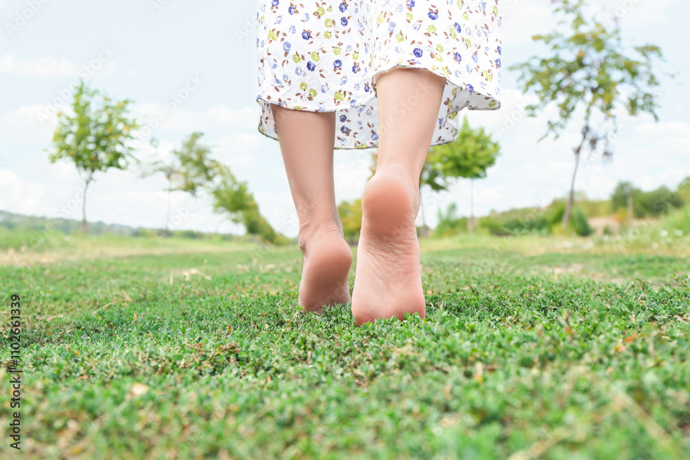 Woman walking barefoot on green grass outdoors, closeup Woman walking barefoot on green grass outdoors, closeup