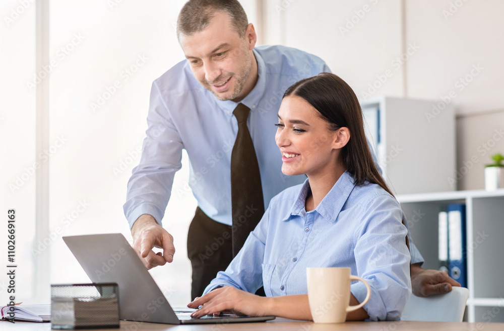Obraz premium Corporate Lifestyle. Cheerful Boss Helping Businesswoman Employee To Work On Business Project Sitting At Laptop In Modern Office. Selective Focus