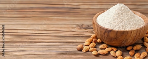 Almond flour in wooden bowl with almonds on rustic wooden surface.