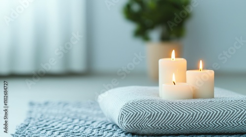 A serene arrangement of lit candles on a soft blanket, creating a calming atmosphere in a softly lit room.