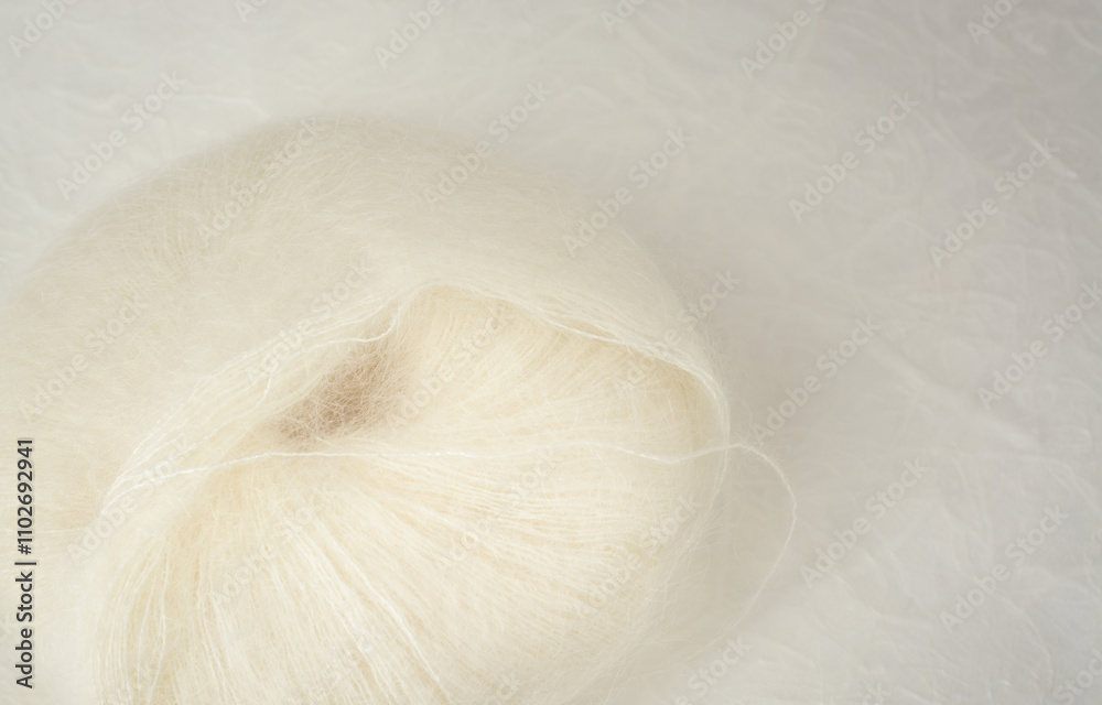 Obraz premium Ball of white mohair wool yarn with copy space