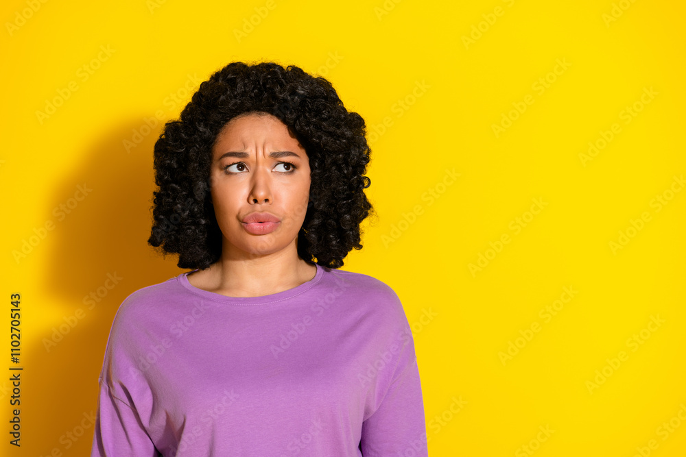 Photo of nice young woman look empty space wear purple pullover isolated on yellow color background Photo of nice young woman look empty space wear purple pullover isolated on yellow color background