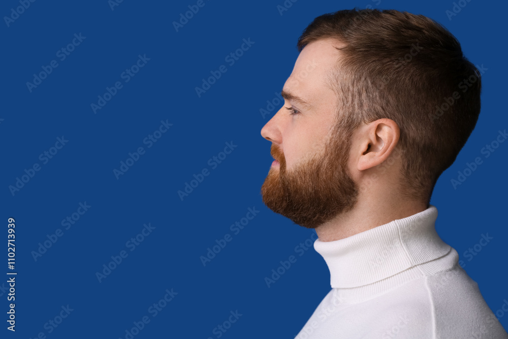 Fototapeta premium Handsome bearded man on blue background, closeup