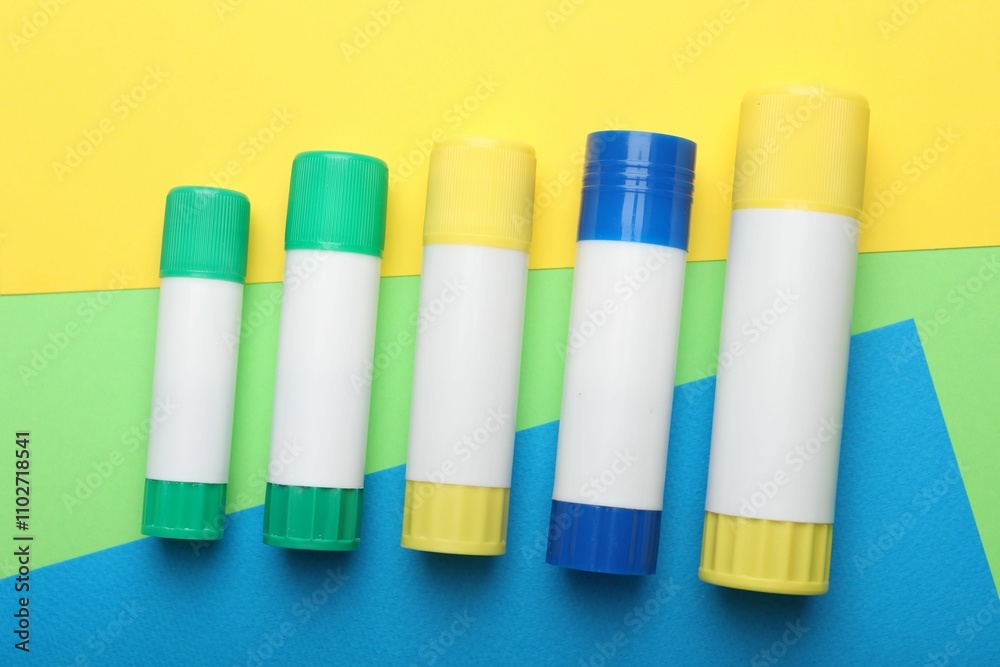 Sticks of glue on color background, flat lay Sticks of glue on color background, flat lay