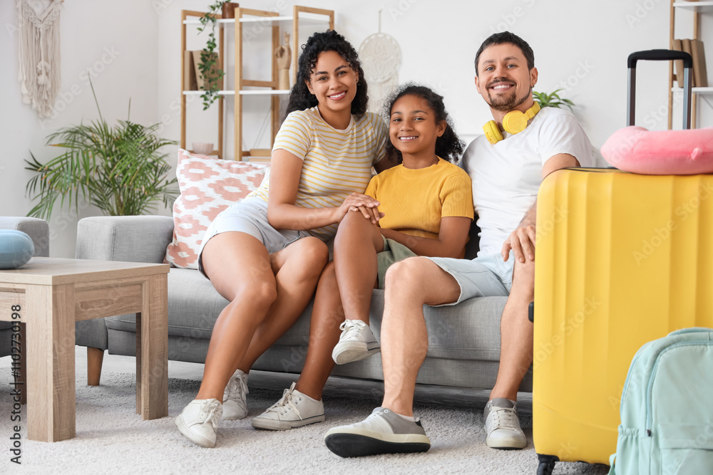 Obraz premium Happy family with packed suitcase for travel sitting on sofa at home