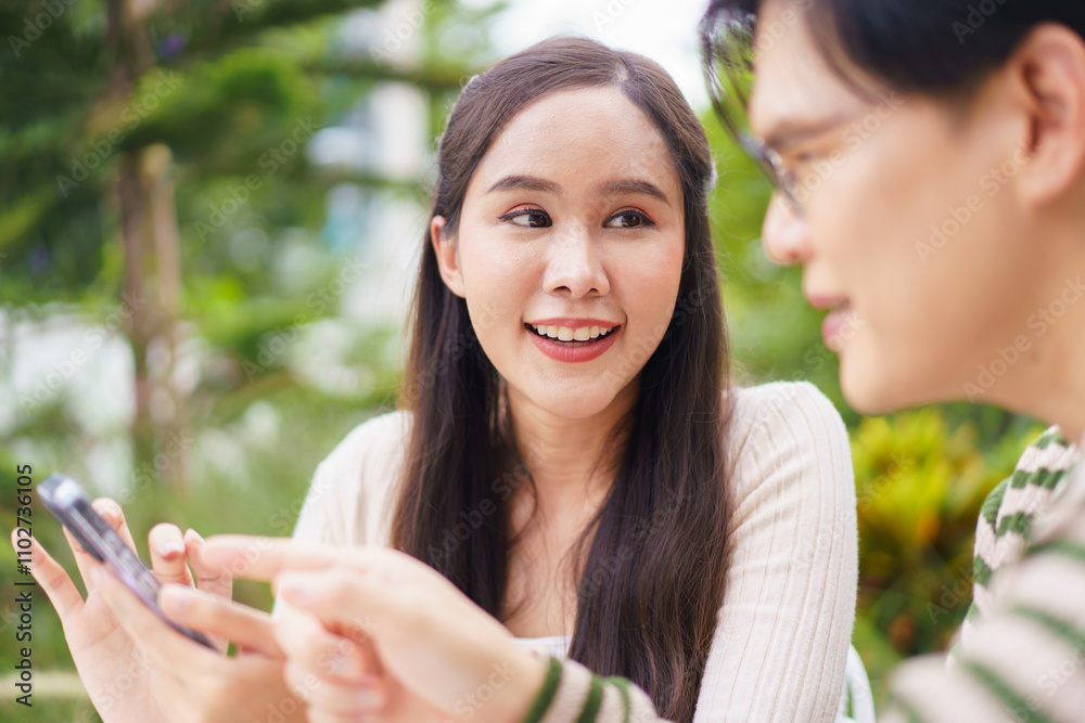 Excited Asian man and woman expressing their happy and satisfied emotion after got a message on smartphone. Excited Asian man and woman expressing their happy and satisfied emotion after got a message on smartphone.