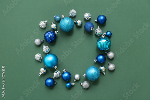 Frame made of different Christmas balls on green background