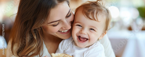 A woman is holding a baby and both of them are smiling photo