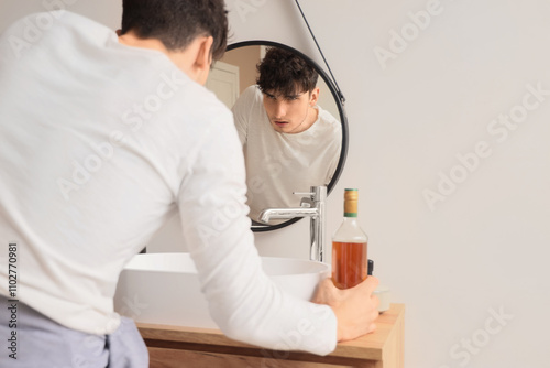 Young man with hangover in ...