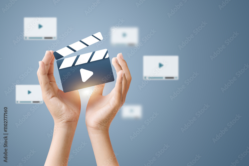 Hands holding a clapperboard with a play icon, representing video production and content creation. Hands holding a clapperboard with a play icon, representing video production and content creation.