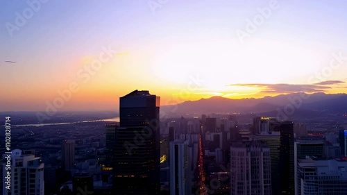 Wallpaper Mural Drone shot of a bustling city skyline at dusk, with lights flickering on as the camera slowly zooms out to reveal the surrounding mountains Torontodigital.ca