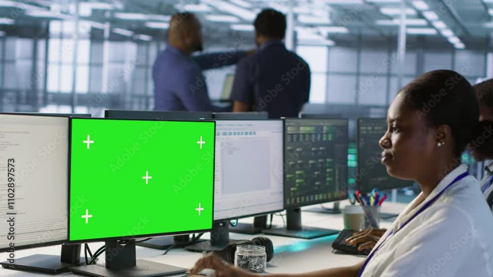 Technician using isolated screen computer, working in server farm to optimize it for data processing requirements. IT professional coding on chroma key PC in data center, camera A Technician using isolated screen computer, working in server farm to optimize it for data processing requirements. IT professional coding on chroma key PC in data center, camera A
