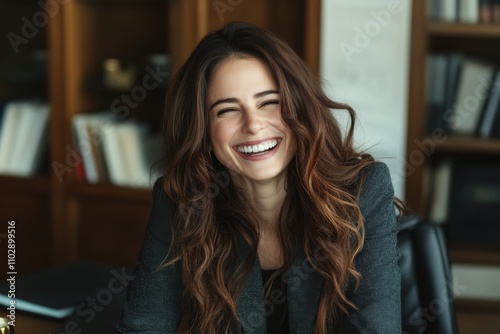 Portrait of laughing businesswoman sitting at desk in the office