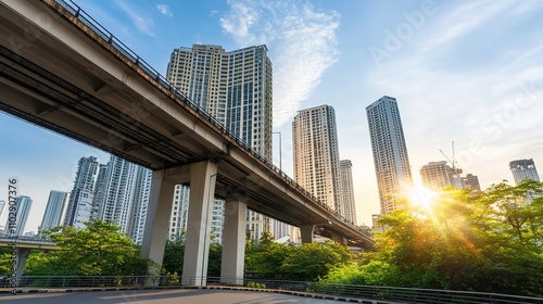 Urban Skyline with Modern Skyscrapers and Elevated Train Tracks Under a Blue Sky and Soft Clouds in a Vibrant City at Sunset