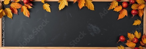 Chalkboard frame toppled with assorted fruits on black background with autumn leaves, copy space, black, empty