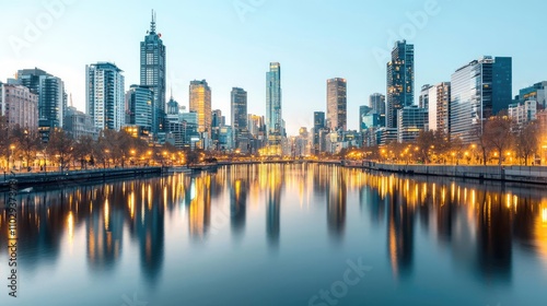 City skyline with reflections in water, illuminated at dusk.