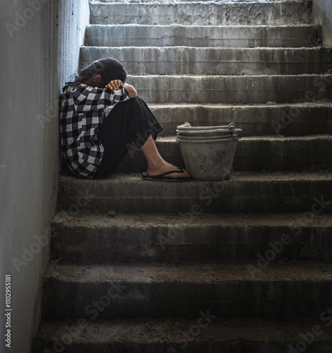 фотографія Exhausted Poor child girl sitting on the stairs at dark room