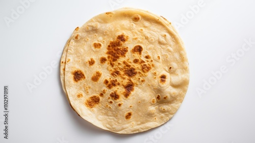 Homemade tortilla beautifully displayed on a white background showcasing its texture and golden-brown spots from cooking