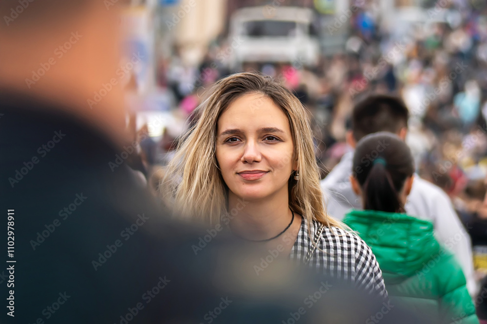 A young beautiful girl is walking along a city street against the movement of the crowd. the idea of a movement against the crowd. meeting of two young people in a crowd of people. date in the city A young beautiful girl is walking along a city street against the movement of the crowd. the idea of a movement against the crowd. meeting of two young people in a crowd of people. date in the city