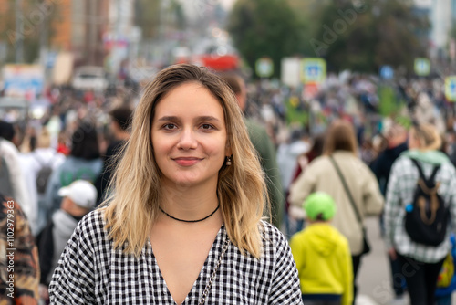 A woman goes against the movement of the crowd during the day in a big city. girl alone in the front of the crowd on the other side of the road.