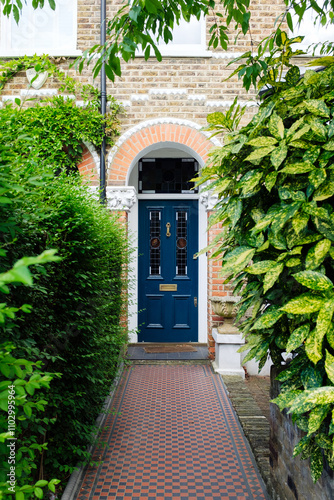 Photography Elegant blue door of traditional london victorian house with checkered pathway a